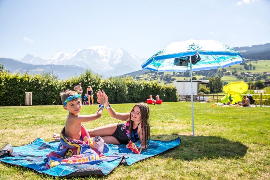 Enfants sous le parasol au plan d'eau biotope
