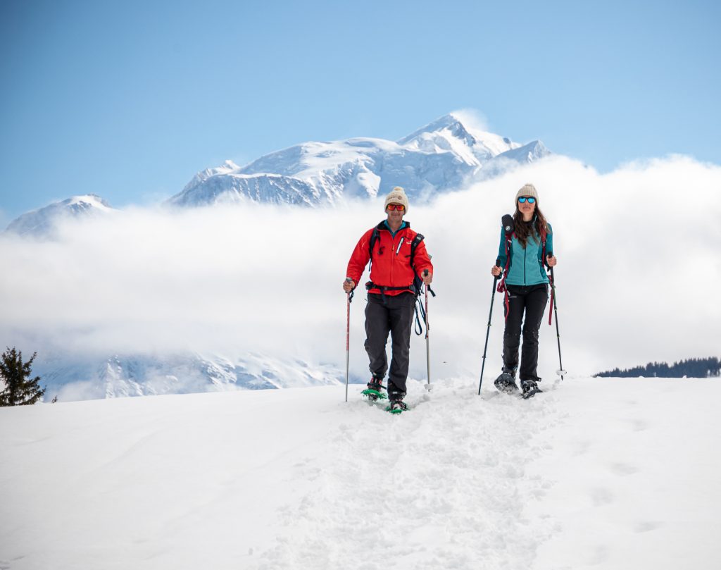 Pareja con raquetas de nieve con el Mont-Blanc de fondo