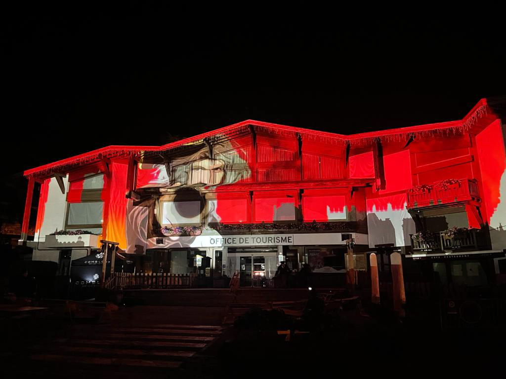 videomapping leyenda de Combloux en la fachada de la oficina de turismo en medio de la noche