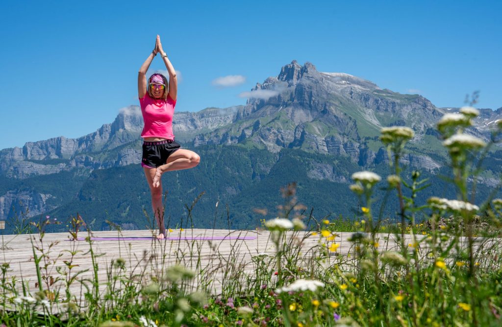 mujer joven haciendo pose de árbol yoga plataforma avión agua frente a fiz
