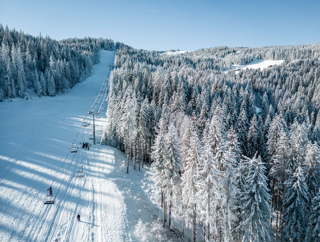 drone view of the ski area of ​​Combloux, snow-covered fir trees, chairlift