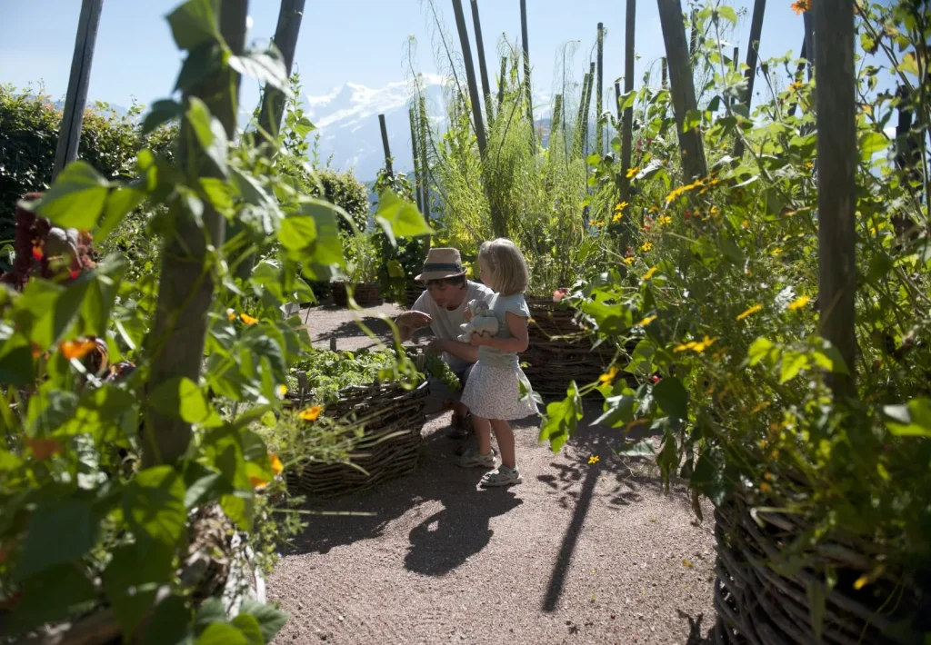 pere et petite fille dans jardin pedagogique face mont blanc