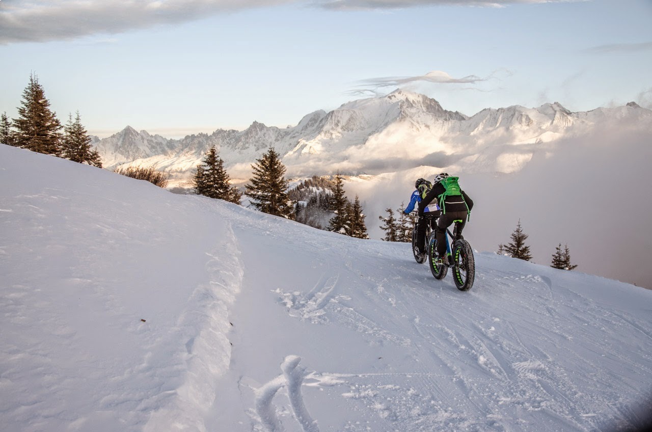 mountain biker on snow facing mont blanc