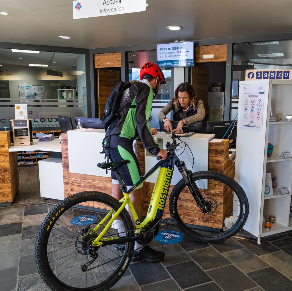 Asesor de viajes en la oficina de turismo de Combloux que proporciona información sobre los ciclistas de montaña.