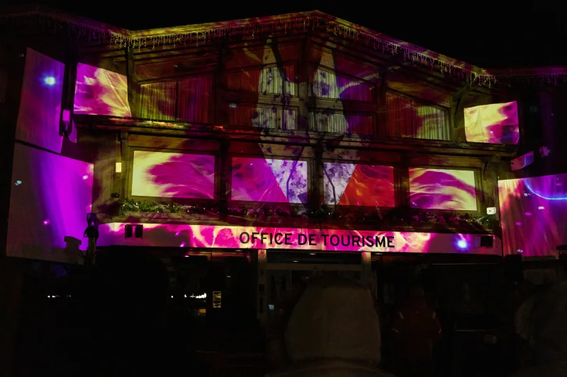 videomapping of the wolf's head projected on the facade of the Combloux tourist office