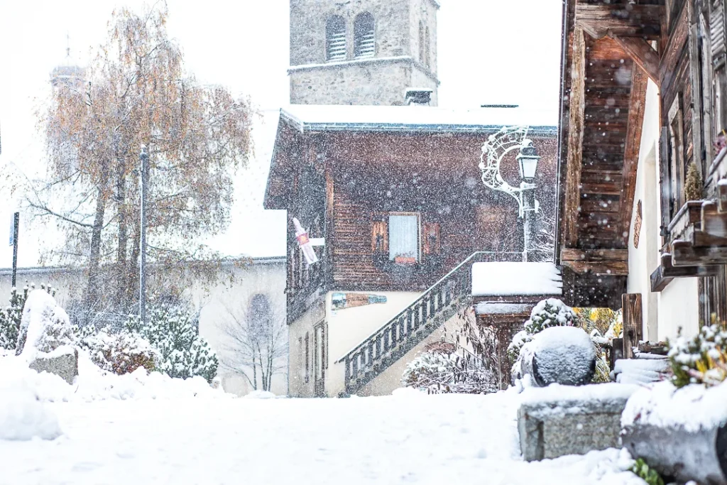 snowfall in progress in front of bakery and church