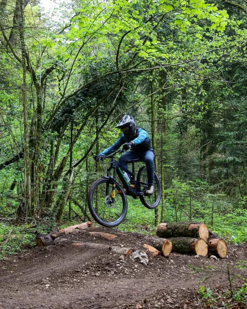 Saut par un cycliste enduro en forêt