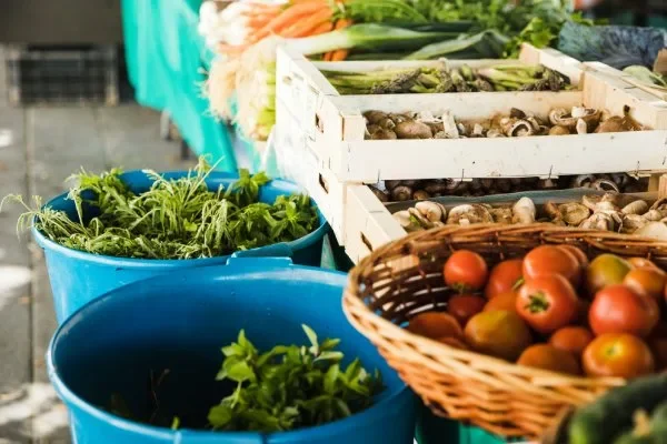 fresh vegetable with mushrooms in wooden crate at market stall