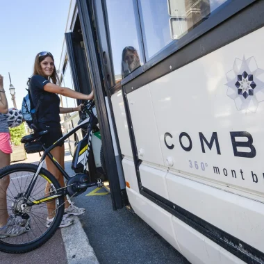 Una joven subiendo al autobús de la estación Combloux con su bicicleta