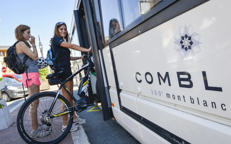 Una joven subiendo al autobús de la estación Combloux con su bicicleta
