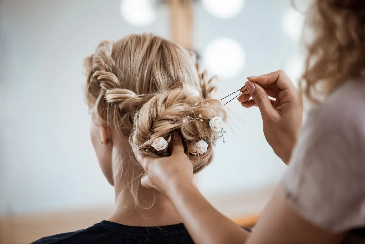 femme blonde de dos se faisant coiffer pour mariage combloux