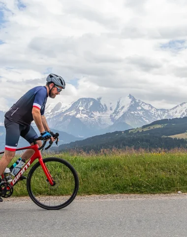 Ciclista en bicicleta de carretera frente al Mont-Blanc en Combloux