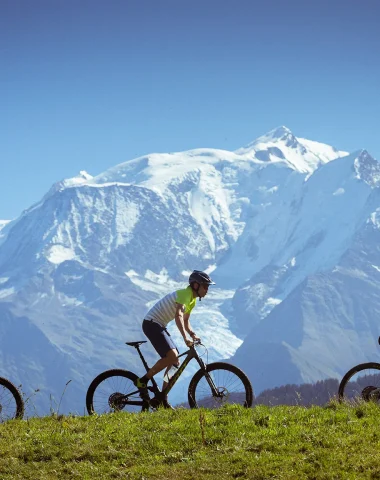 3 personas en bicicleta de montaña frente al Mont-Blanc en Combloux