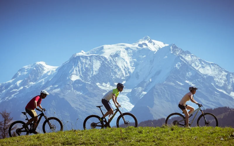 3 personas en bicicleta de montaña frente al Mont-Blanc en Combloux