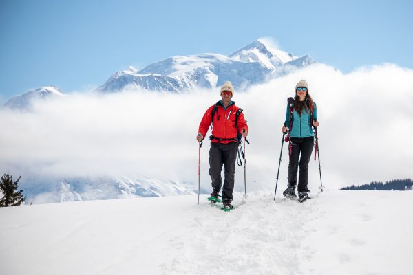 Pareja con raquetas de nieve con el Mont-Blanc de fondo en Combloux